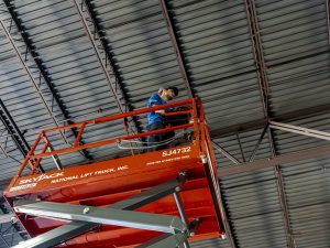 man working on a scissor lift for operator training at National Lift Truck