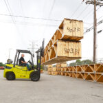 Clark GTS Series outdoor pneumatic tire forklift lifting materials outdoors in a shop yard