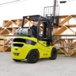 Clark forklift moving lumber outside