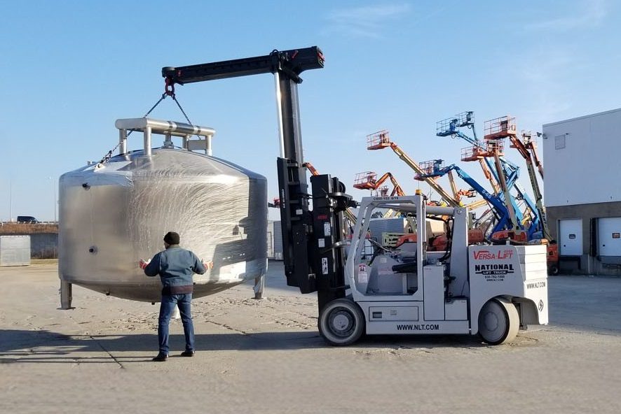 Versa Lift high-capacity lift truck with boom attachment lifting a large tank